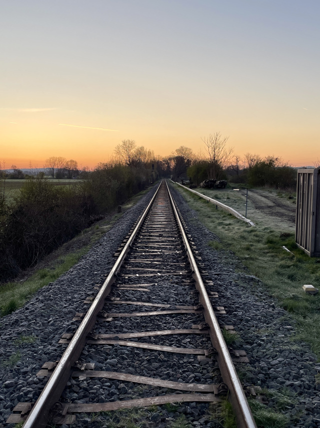 Blick entlang von Eisenbahngleisen zum Sonnenaufgang