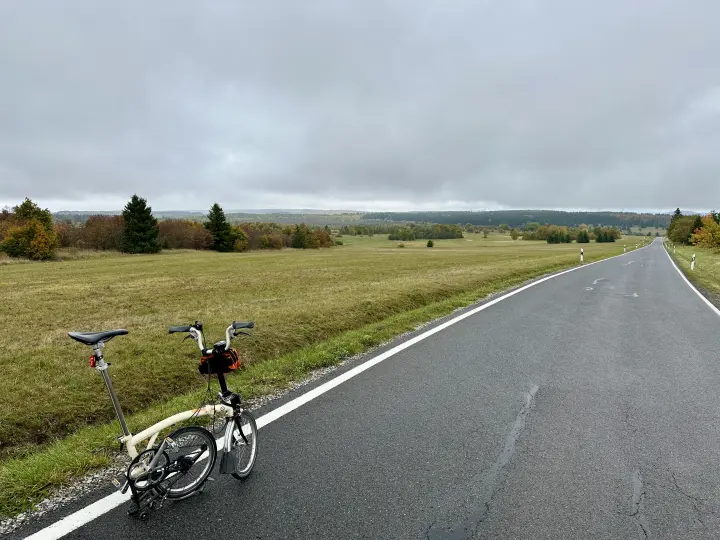 Straße in der langen Rhön mit Klapprad und Blick aufs Schwarze Moor